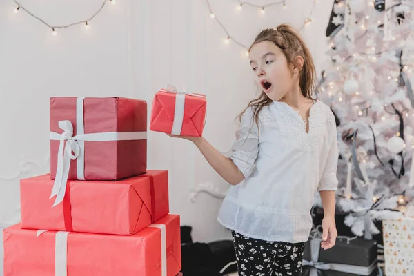 Jolie petite fille jouant avec des boîtes-cadeaux de Noël, construisant une pyramide . — Photo