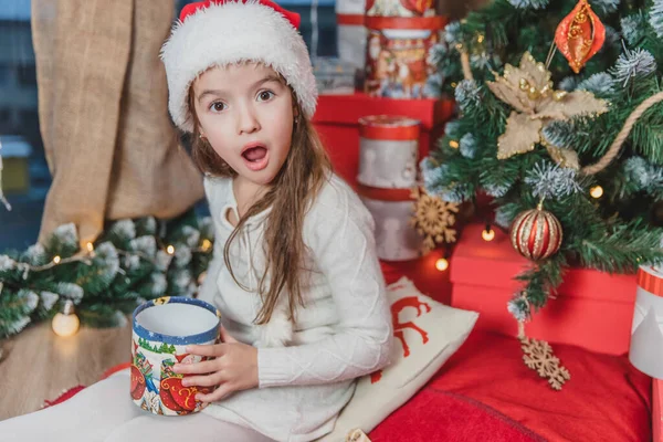 Foto que muestra una sorpresa y la impresión de niño lindo que abrió un regalo de año nuevo . — Foto de Stock