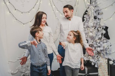 Çocukların kızgın yüzlü ailelerine baktığı yeni yıl fotoğrafı, olumsuz işaretler baş parmakları aşağıda hoşnutsuzluğu gösteriyor.