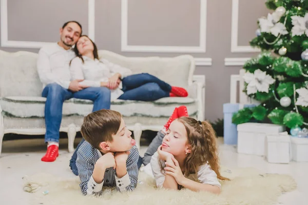 Los miembros encantadores de la familia en calcetines rojos están en previsión de año nuevo. Los niños están haciendo muecas en la vanguardia . — Foto de Stock