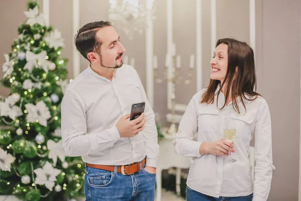 Концепция вечеринок и развлечений. Сладкая фотография празднующей семейной пары с шампангом в красивой новогодней украшенной комнате . — стоковое фото