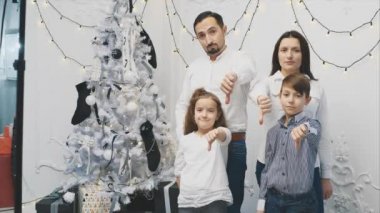 Çocukların ve ailelerinin yılbaşı zamanı somurtkan suratlar, olumsuz işaretler baş parmakları aşağıda hoşnutsuzluğu gösteriyor.