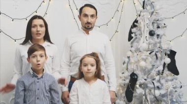 Genç ebeveynlerin ve çocuklarının yeni yıl arka planında ağızları açık, elleri yanaklarında kameraya korku dolu gözlerle bakarken videolarını izledik..