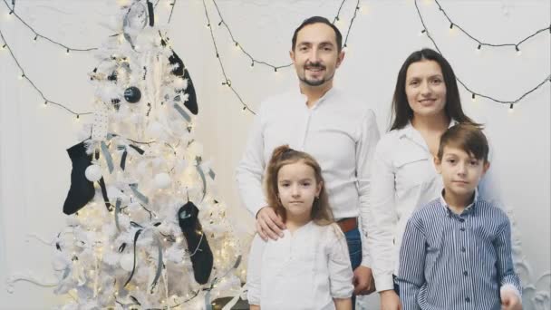 可爱的父母和小孩站在圣诞树旁，摆出姿势，竖起大拇指. — 图库视频影像