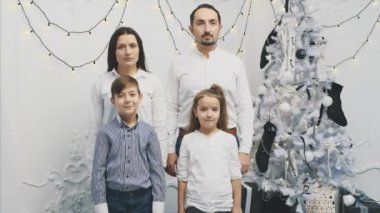 Çocuklar umutsuzca gülerken ebeveynlerin üzgün ve ciddi bir şekilde dikildiği 4K videosu..