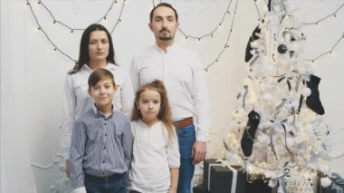 4K videoda ebeveynler asker gibi duruyorlar, üzgün ve ciddi, çocukları gülümserken..