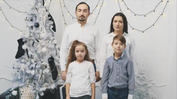 El estado de ánimo incomprensible de los padres y los niños de pie molesto cerca del árbol de Navidad, mientras que la Navidad es el momento de sonreír y celebrar . — Vídeo de stock