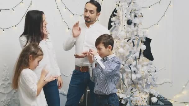 Rodiče a dva sourozenci se shromáždili u vánočního stromku a popřáli si nový rok, ohýbali prsty.