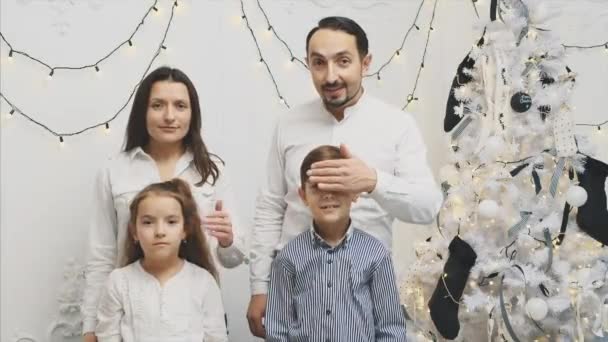 Родители закрывают детям глаза руками, как будто готовят рождественский сюрприз, а потом показывают, что у них нет денег на подарки для детей . — стоковое видео