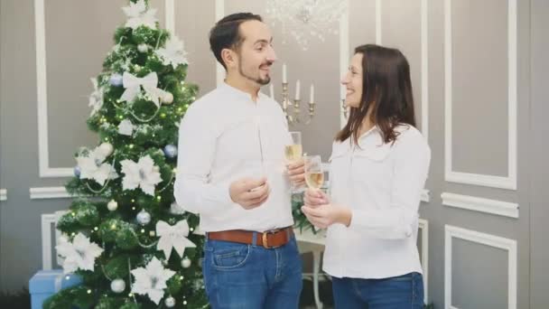 Романтична молода пара ділиться тостом, чіпляючись за келихи білого вина і глибоко дивлячись один на одного в очі . — стокове відео