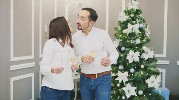 Romántica joven pareja compartir un brindis tintineo sus copas de vino blanco besos y relámpagos bengala luces . — Vídeos de Stock