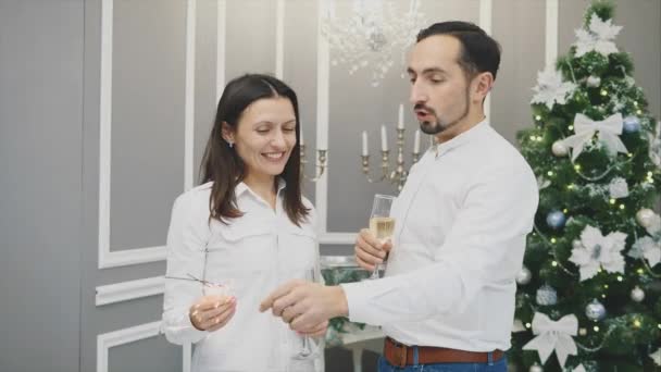 Jonge man en vrouw maken plezier, vechten met bengaalse lichten, vieren Nieuwjaar. — Stockvideo