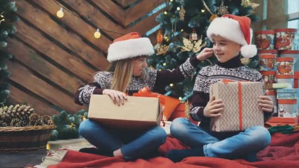 Сын и дочь приготовили рождественские подарки для своих родителей и показывают их в камеру, гордясь тем, что они сделали . — стоковое видео