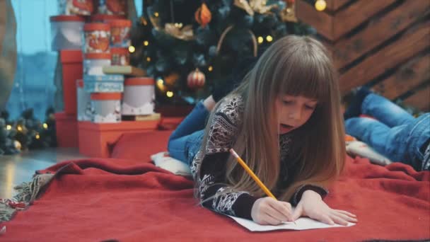 Счастливый ребенок в вязаном свитере оленя, запечатывая конверт Санте с рождественскими подарками список пожеланий . — стоковое видео