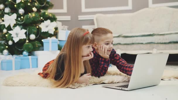 4k vídeo of amazing siblings buying christmas presents online with laptop together . — Vídeo de Stock