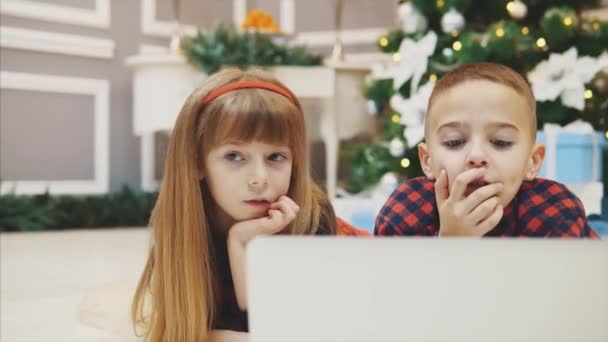 Close-up 4k video van verbazingwekkende broers en zussen kopen kerstcadeaus online met laptop samen. — Stockvideo