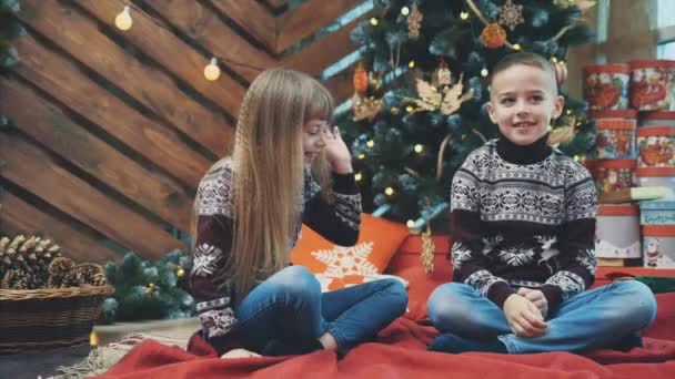 Slowmotion 4k video av barn som ger high-five i väntan på Santa under julgran. — Stockvideo