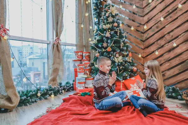 Retrato de niño y niña riendo, divirtiéndose juntos, jugando juego de palmadas sobre fondo de Navidad de madera . — Foto de Stock
