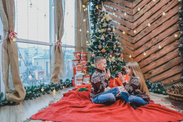 Retrato de niño y niña riendo, divirtiéndose juntos, jugando juego de palmadas sobre fondo de Navidad de madera . — Foto de Stock