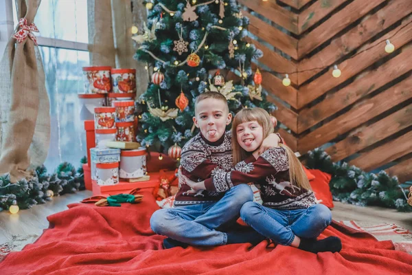 Immagine di fratello e sorella che si abbracciano teneramente nel periodo natalizio su sfondo di legno . — Foto Stock
