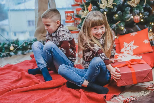 Avida sorella ha rubato fratelli presenti e guarda la fotocamera con astuzia faccia espressione, mentre ffended ragazzo è seduto vicino a lei guardando sconvolto . — Foto Stock