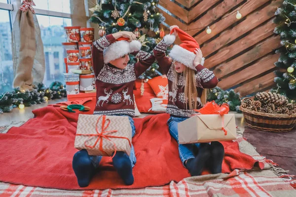 Des enfants inspirants jouent, s'assoient par terre, font du sport, avec des boîtes-cadeaux sur les jambes . — Photo