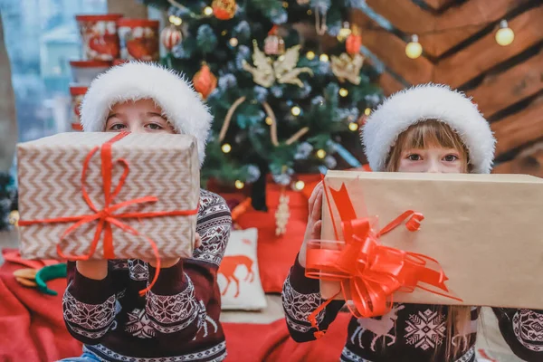 儿子和女儿给父母准备了圣诞礼物，并在镜头前展示他们的近照，为他们所做的一切感到自豪. — 图库照片