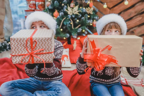 Κοντινές φωτογραφίες του γιου και της κόρης που ετοίμασαν χριστουγεννιάτικα δώρα για τους γονείς τους και τα δείχνουν στην κάμερα, δείχνοντας περήφανοι για ό, τι έχουν κάνει. — Φωτογραφία Αρχείου