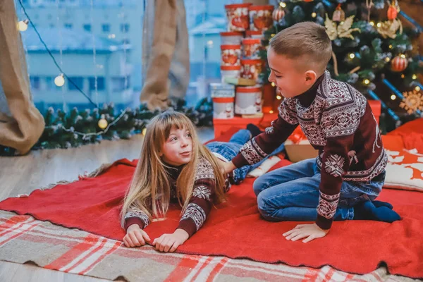 Foto bonita de irmão e irmã curtindo o tempo juntos no abeto na noite de Natal . — Fotografia de Stock