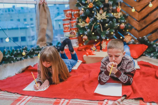Duas crianças doces estão escrevendo mensagem para o Papai Noel . — Fotografia de Stock