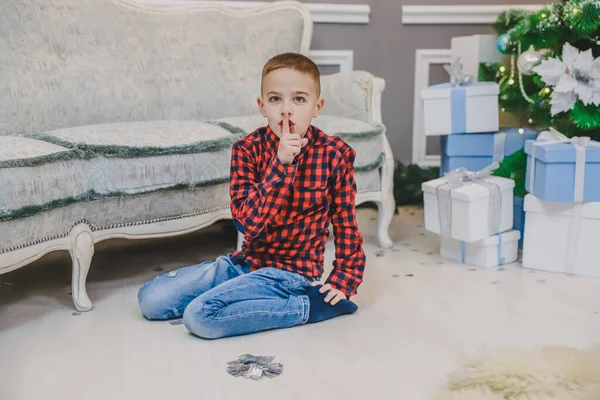 Retrato de comprimento total de pequeno ladrão, gesticulando silêncio, com a intenção de roubar caixas de presente isoladas no fundo de Natal . — Fotografia de Stock