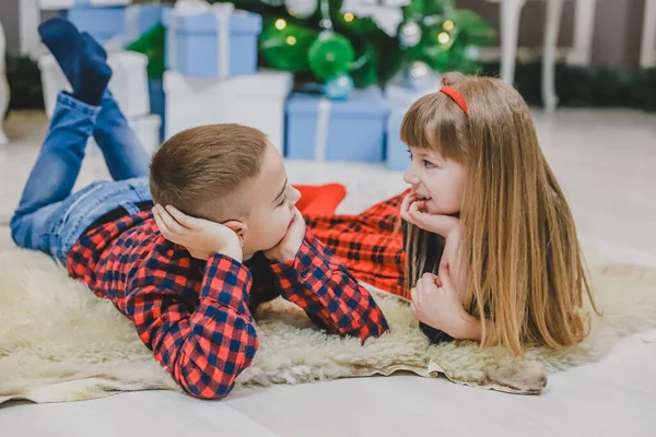 Lindo poco pasar tiempo agradable juntos, la comunicación en la alfombra cerca del árbol de Navidad . — Foto de Stock