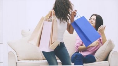 Kafkasyalı kız elinde telefonla kanepede oturmuş, mesajlaşıyordu. Arkadaşı da ona katılıyor, dükkandan bir sürü çanta getiriyor. Alımlara bakmaya başlarlar..