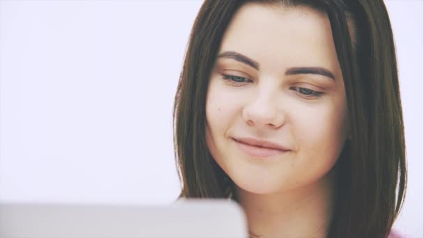 Cute caucasian brunette girl with laptop, surfing in the internet, smiling, raising eyebrows, nodding her head. — Stock Video