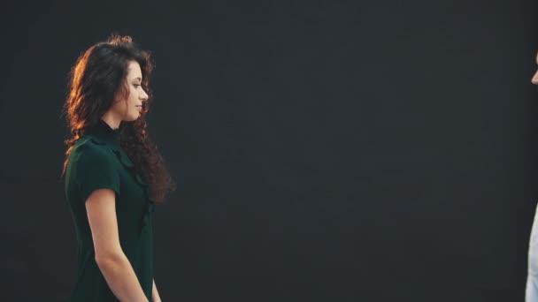 Cute curly brunette girl standing in profile. Courier comes and gives her a bouquet of red roses. She puts a signature and looks at the flowers with surprise. — Stock Video