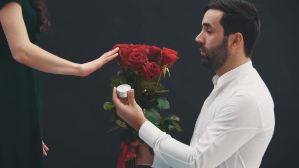 Un bel homme se tient debout sur un genou, avec une bague et des roses à la main, faisant sa demande en mariage à sa femme. Elle dit non. Le malheureux s'en va, déçu . — Video