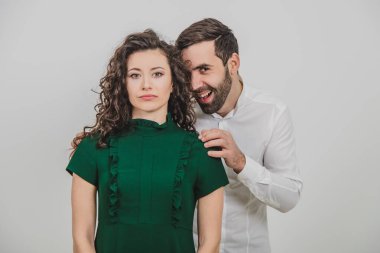 Adam sanki kız arkadaşına sinsice ve tuhaf bir şey yapmayı düşünmüş gibi sırıtıyor. Bu da ona geri çekiliyor, sakin ve sarsılmaz..