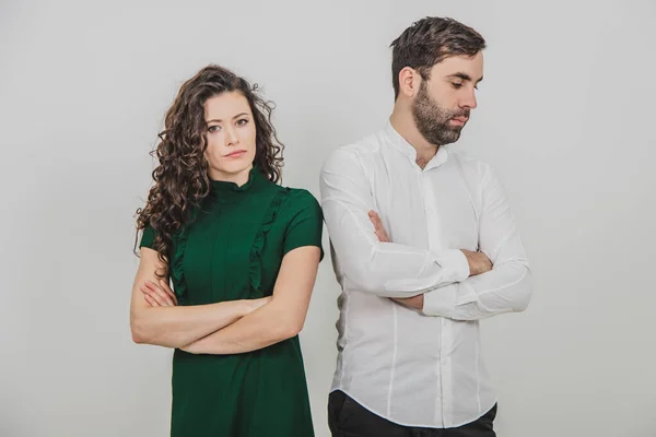 Retrato de jovem casal após argumento de pé separadamente com as mãos dobradas sobre fundo branco . — Fotografia de Stock