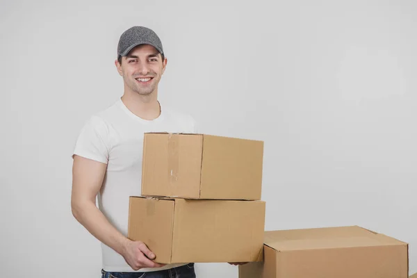 Leverancier staande, met twee kartonnen dozen, kijkend naar de camera, glimlachend. — Stockfoto