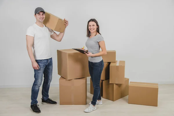 Mulher encantadora chamado no homem de entrega para transportar todas as caixas de papelão em seu novo apartamento . — Fotografia de Stock