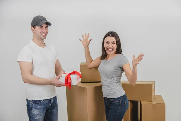 Courier delivered present for young woman who is moving into new apartment. Woman is really surprised. — Stock Photo, Image