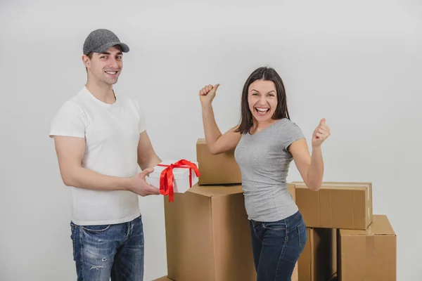 Courier delivered present for young woman who is moving into new apartment. Woman is really surprised and excited. — Stock Photo, Image