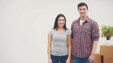 Yeni dairelerde mutlu bir kadın ve erkek, gülümsüyor. Adam anahtarları gösteriyor, kadın başparmağını bırakıyor..