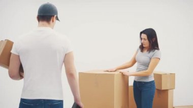 Genç bir kadın yeni bir yere taşınıyor. Karton kutuları yeni daireye taşıması için bir kurye çağırmış..