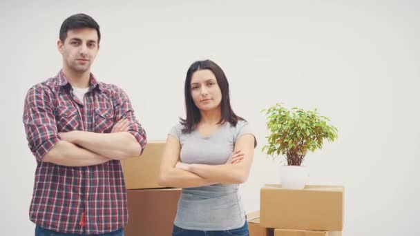 Agradable hombre y mujer de pie en nuevos apartamentos, sonriendo, mirando a su alrededor, con las manos cruzadas. El hombre está mostrando las llaves de un nuevo piso . — Vídeos de Stock