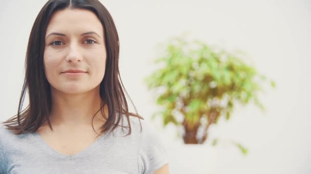 Mulher bonita com sorriso brilhante, olhando para a câmera, dando o polegar para cima, segurando palma aberta para texto ou produto . — Vídeo de Stock