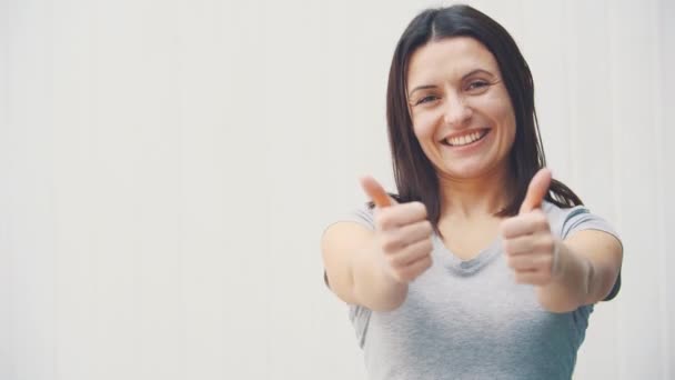 Young happy cheerful woman is showing thumbs up, smiling. — Stock Video