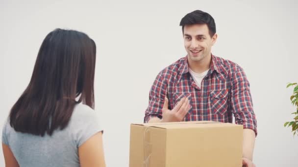 Para wprowadza się do nowego mieszkania. Kobieta krzyczy na mężczyznę, bo umieścił wielkie kartonowe pudełka w złym miejscu.. — Wideo stockowe