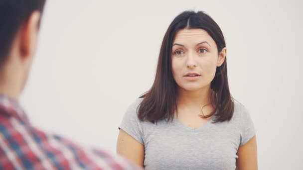 The young couple have a conflict, reacting emotionaly. Blurred man on the forefront. — Stock Video