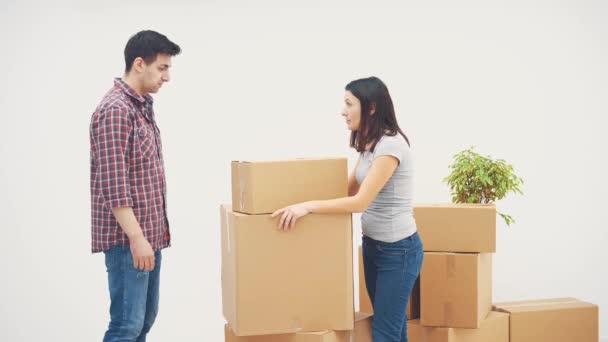 Couple is moving into new flat. They have a quarrel, because dont know where to put all those big cardboard boxes. — Stock Video